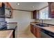 View of kitchen with wood cabinets, tile floor, black appliances, and neutral walls at 5345 Silvermist Ct # 203, Las Vegas, NV 89122