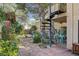 Well-maintained backyard featuring a spiral staircase, patio, and lush greenery at 5785 N Tee Pee Ln, Las Vegas, NV 89149