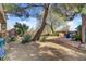 Wide backyard shot showcasing desert landscaping and mature trees providing ample shade at 5785 N Tee Pee Ln, Las Vegas, NV 89149