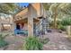 Inviting backyard area with a spiral staircase, tiled patio, and mature trees offering shade at 5785 N Tee Pee Ln, Las Vegas, NV 89149