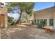 Backyard patio with desert landscaping, gravel, and mature trees, providing a tranquil outdoor setting at 5785 N Tee Pee Ln, Las Vegas, NV 89149