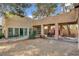 Large covered backyard patio with multiple seating areas, complemented by desert landscaping and mature trees at 5785 N Tee Pee Ln, Las Vegas, NV 89149