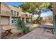 Multi-level backyard with a covered patio, desert landscaping, and multiple seating areas for relaxation and entertaining at 5785 N Tee Pee Ln, Las Vegas, NV 89149