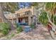 Large backyard featuring desert landscaping, mature trees, outdoor dining, and unique architecture at 5785 N Tee Pee Ln, Las Vegas, NV 89149
