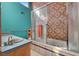 Bathroom featuring a bathtub-shower combo with a glass sliding door and decorative tile at 5785 N Tee Pee Ln, Las Vegas, NV 89149