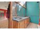 Bathroom featuring dual sinks, wood cabinets, light blue colored walls and tile floors at 5785 N Tee Pee Ln, Las Vegas, NV 89149