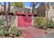 Unique gated entrance with red double doors and desert landscaping at 5785 N Tee Pee Ln, Las Vegas, NV 89149