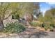 Gated entrance surrounded by mature trees and desert landscaping at 5785 N Tee Pee Ln, Las Vegas, NV 89149