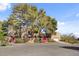 The front exterior of the home shows large trees and mature landscaping at 5785 N Tee Pee Ln, Las Vegas, NV 89149