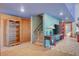 Inviting living area featuring tile floors, open shelving, and staircase access at 5785 N Tee Pee Ln, Las Vegas, NV 89149