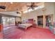 Spacious main bedroom with red concrete floors, wood ceiling, ceiling fans, and sliding glass doors to balcony at 5785 N Tee Pee Ln, Las Vegas, NV 89149