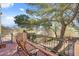 Relaxing second story patio with outdoor seating overlooks the well-maintained yard and mature landscaping at 5785 N Tee Pee Ln, Las Vegas, NV 89149