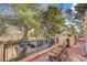 Inviting second story patio with comfortable seating, offering views of the lush yard and surrounding greenery at 5785 N Tee Pee Ln, Las Vegas, NV 89149