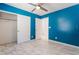 Bedroom with blue walls, ceiling fan and closet, showcasing ample space and modern style at 6345 Strongbow Dr, Las Vegas, NV 89156