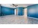 Spacious bedroom with blue walls, modern ceiling fan, and closet, with tile flooring at 6345 Strongbow Dr, Las Vegas, NV 89156