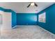 Bright bedroom with large window, tile floor, ceiling fan and blue accent wall at 6345 Strongbow Dr, Las Vegas, NV 89156
