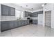 Modern kitchen features gray cabinets, stainless steel appliances, stylish backsplash, and tile flooring at 6345 Strongbow Dr, Las Vegas, NV 89156