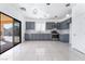 Modern kitchen showcasing gray cabinetry, stainless steel appliances, a sliding door, and tile flooring at 6345 Strongbow Dr, Las Vegas, NV 89156
