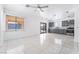 An open living room showcasing gray cabinets, sleek tile flooring, and an open slider door to a backyard at 6345 Strongbow Dr, Las Vegas, NV 89156