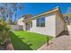 A bright backyard with synthetic grass and a white stucco wall creates a low-maintenance space at 669 Elliot Peak Ave, Las Vegas, NV 89183