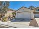 Single-story home with a two-car garage and desert landscaping in the front yard at 669 Elliot Peak Ave, Las Vegas, NV 89183