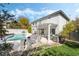 Lush backyard featuring a large in-ground pool, covered patio, and mature trees, perfect for outdoor entertaining at 6695 Shadow Cove Ave, Las Vegas, NV 89139