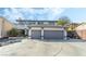 Two-story home with a three-car garage and driveway with manicured landscaping and a balcony at 6695 Shadow Cove Ave, Las Vegas, NV 89139