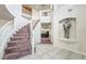 Spacious foyer with a grand staircase, tiled flooring, and a unique decorative knight statue at 6695 Shadow Cove Ave, Las Vegas, NV 89139