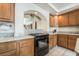 Well-appointed kitchen featuring a granite countertop, gas stove, and wooden cabinetry at 6695 Shadow Cove Ave, Las Vegas, NV 89139