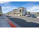 A row of modern townhomes feature attached garages, set along a tree-lined street with parked cars at 7304 N Decatur Blvd # 6, North Las Vegas, NV 89131