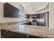 Contemporary kitchen boasts dark wood cabinetry, granite countertops, and stainless steel appliances at 845 Holly Lake Way, Henderson, NV 89002