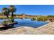 Gorgeous infinity pool overlooking a serene lake and mountain landscape with clear blue skies and palm trees at , Henderson, NV 89011