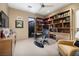 Well-lit office with custom built-in shelves, a glass desk, and a comfortable sitting area at , Henderson, NV 89011