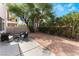 Private backyard with mature trees, gravel landscaping, concrete patio and patio furniture at 1030 Wild Fern Ct, Las Vegas, NV 89183