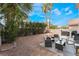 Backyard featuring decorative gravel, patio with seating, barbecue, and mature palm trees at 1030 Wild Fern Ct, Las Vegas, NV 89183