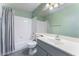 Bright bathroom with white tile, a large mirror, and a shower-tub combination with grey shower curtain at 1030 Wild Fern Ct, Las Vegas, NV 89183