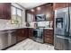 Gourmet kitchen with stainless steel appliances, granite countertops, and rich wood cabinetry at 1030 Wild Fern Ct, Las Vegas, NV 89183