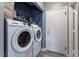 Convenient laundry room with modern white washer and dryer and storage shelves at 1030 Wild Fern Ct, Las Vegas, NV 89183