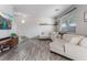 Comfortable living room with hardwood floors, a neutral sectional sofa, and large windows for natural light at 1030 Wild Fern Ct, Las Vegas, NV 89183