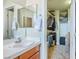 Bathroom with white sink, wood cabinets, mirror and walk-in closet at 1156 Harts Bluff Pl # 3, Henderson, NV 89002