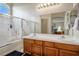 Bathroom with dual sinks, large mirror, combination shower and tub and natural wood cabinets at 1156 Harts Bluff Pl # 3, Henderson, NV 89002