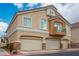 Tan two-story home featuring a three-car garage, light stone accents and architectural interest at 1156 Harts Bluff Pl # 3, Henderson, NV 89002