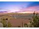 Rooftop view captures a vibrant sunset over the city skyline and the surrounding mountains at 12125 Edgehurst Ct, Las Vegas, NV 89138