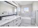Modern bathroom featuring double vanity, marble accents, and a soaking tub at 1216 Padre Serra Ln, Las Vegas, NV 89134