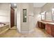 Luxurious bathroom featuring double vanities, marble flooring, and a tiled backsplash at 14 Camino Barcelona Pl, Henderson, NV 89011