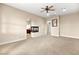 Spacious carpeted room with a fireplace, ceiling fan, and an arched entryway at 14 Camino Barcelona Pl, Henderson, NV 89011