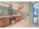 Bathroom featuring double sinks, vanity, shower with glass door, and tiled flooring at 1532 Via Cassia, Henderson, NV 89052