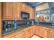Close up view of kitchen with custom wood cabinets, dark granite countertop, and gas stovetop at 1532 Via Cassia, Henderson, NV 89052
