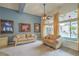 Bright living room with large windows overlooking the pool, two sofas, and modern ceiling fan at 1532 Via Cassia, Henderson, NV 89052