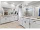 Bright bathroom featuring double sinks, a large mirror, and a walk-in closet at 160 Stone Mesa Ct, Henderson, NV 89011